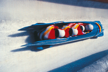 Das Bild zeigt einen Viererbob im Eiskanal. (verweist auf: Sport inside berichtet über Kopfverletzungen im Bob- und Rennrodelsport)
