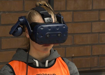 Das Foto zeigt eine n junge Fußballerin, die auf einem Stuhl sitzt und eine VR-Brille trägt (verweist auf: Aus­wirkungen des Kopf­ball­spiels: neues Projekt­video zum Forschungs­schwer­punkt SHT)